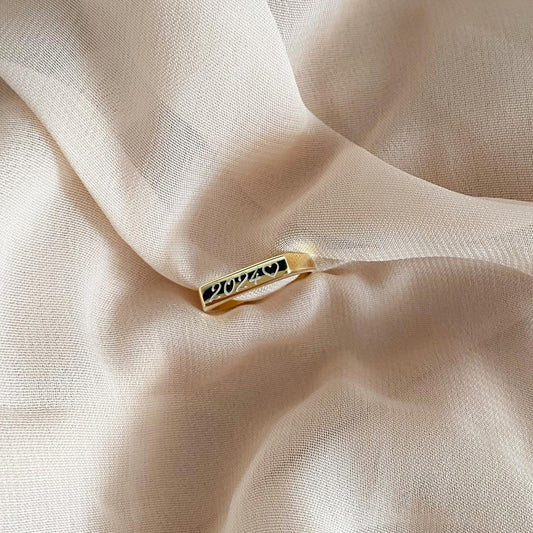 Un anillo de color dorado con un número grabado en su superficie.